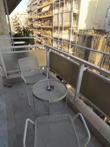 a table and chairs on a balcony with buildings at Athina Pantheon Mitropoleos in Thessaloniki
