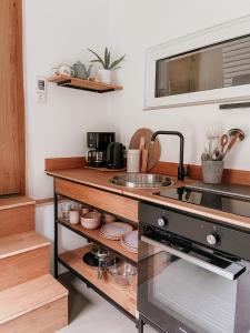 - une cuisine avec un évier et un comptoir dans l'établissement Modernes Tinyhouse Trailer Cabins am Waldrand - mit Seezugang, à Eging am See