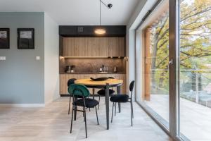 een keuken met een houten tafel en stoelen bij Apartamenty EverySky - Kilińskiego 8 in Szklarska Poręba