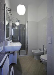 uma casa de banho branca com um lavatório e um WC em Colibri B&B em Sciacca