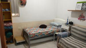 Habitación pequeña con cama y sofá en Flat Botafogo, en Río de Janeiro