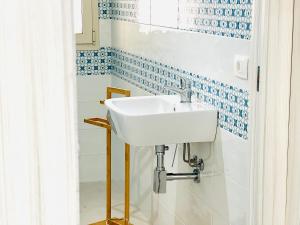 a white sink in a bathroom with blue and white tiles at Sunlands 50 meters from the sandy beach with wifi in Avola +44 photos