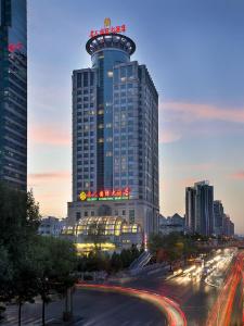 um edifício alto com uma placa no topo em Celebrity International Grand Hotel em Pequim