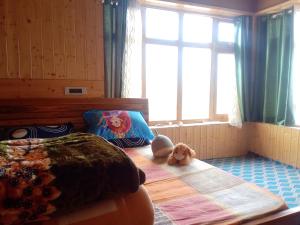 a bedroom with a bed with a teddy bear on it at Tsabgyat Homestay in Leh