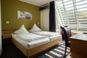 Un pat sau paturi într-o cameră la Hotel Burg Kerpen