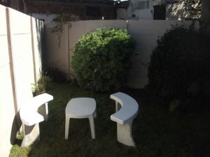 un patio con 2 sillas y un taburete blanco en Alquiler Por Dia Tandil - Mas De 200 Recomendaciones En Face Nos Avalan - 10 Años De Experiencia en Tandil