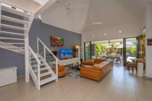 a living room with a staircase and a couch at Balinea Villas in Pereybere