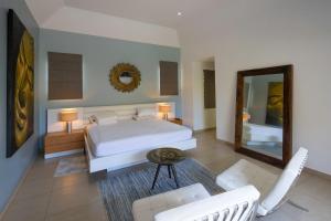 1 dormitorio con cama blanca y espejo en Balinea Villas, en Pereybere