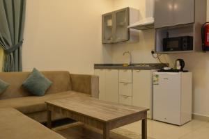 a living room with a couch and a table and a kitchen at بيت الماس للشقق المخدومة MAAS House Apartments in Abha