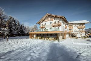 un gran edificio con nieve en el suelo en Crystls Aparthotel, en Flachau