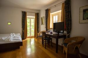 a hotel room with a desk and a bed and a bedroom at Hotel Burg Kerpen in Illingen
