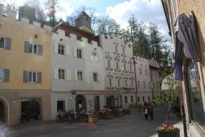 eine Gruppe von Gebäuden auf einer Straße mit Menschen gehen in der Unterkunft Hotel Krone in Bruneck