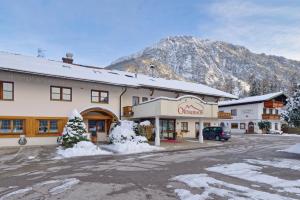 um grande edifício com uma montanha ao fundo em Ortnerhof -Das Wohlfühlhotel em Ruhpolding