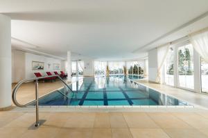 una piscina en una casa con ventanas grandes en Ortnerhof -Das Wohlfühlhotel en Ruhpolding