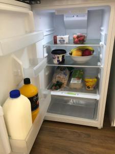 an open refrigerator with a gallon of milk and food at Lakeside Bungalow in Marks Point