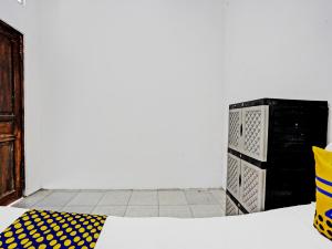 una camera con un letto con un cuscino giallo e nero di OYO 92086 Fun Guesthouse Syariah a Mojokerto