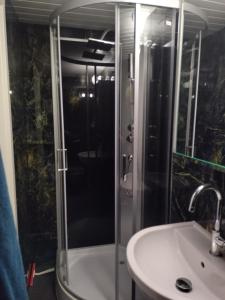 y baño con ducha y lavamanos. en Spacieux studio 38m2 avec sauna en Les Paccots
