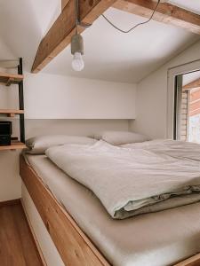 - une chambre avec un grand lit et un cadre en bois dans l'établissement Modernes Tinyhouse Trailer Cabins am Waldrand - mit Seezugang, à Eging am See