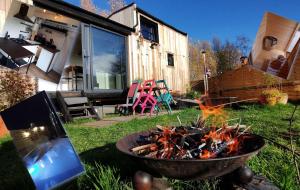 a fire pit in a yard next to a house at Tiny house, sauna hot tub Gesves Namur Ardennes in Gesves