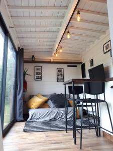 a bedroom with a bed and a desk and a table at Tiny house, sauna hot tub Gesves Namur Ardennes in Gesves