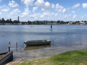 Lakeside Bungalow في Marks Point: وجود قارب يجلس في الماء على البحيرة