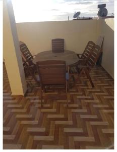 a wooden table and chairs on top of a patio at Appartements agadir 2,5km de la plage in Agadir