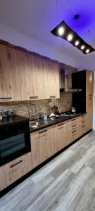 cocina con armarios de madera, fregadero y fogones en TSUKI House en Marino