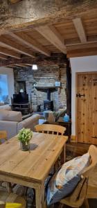 uma sala de estar com uma mesa de madeira e um piano em Cringley Cottage em Askrigg