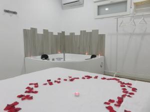 Pokój z czerwonymi różami na łóżku z wanną w obiekcie Afrodita. Magnifica casa con bañera de hidromasaje w mieście Punta Umbría