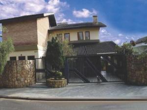 a house with a black gate in front of it at Casa cinematografica em Atibaia in Atibaia