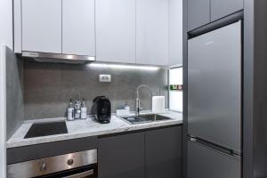 a kitchen with white cabinets and a sink at St'Petar apartment in Skopje