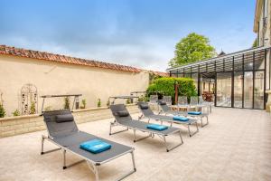 une rangée de chaises et de tables sur une terrasse dans l'établissement HÔTEL DE LUXE Particulier Hammam Sauna Gym - PERCHE, à Tourouvre