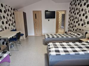 Zimmer mit 2 Betten, einem Tisch und einem TV in der Unterkunft NOCLEGI u ALI in Wałbrzych
