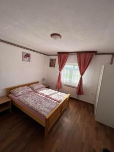 a bedroom with a bed and a window at Apartments Marija in Vrelo Koreničko