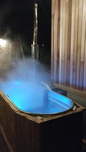 a blue bath tub with a building in the background at Tiny house, sauna hot tub Gesves Namur Ardennes in Gesves