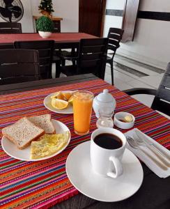 a table with a cup of coffee and a plate of breakfast food at Piccolo Bed & Breakfast in Tarapoto