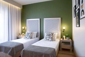 2 camas en una habitación con paredes verdes en Central Hotel, Trademark Collection by Wyndham, en Bucarest