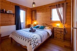 a bedroom with a bed in a wooden cabin at Bel appartement au calme vue vallée in Sainte-Foy-Tarentaise