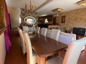 Villa Ingrid. Piscina exterior. في لاس بلايتاس: غرفة طعام مع طاولة خشبية وكراسي بيضاء