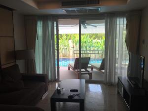 sala de estar con sofá, mesa y TV en AMAZING BIG APARTMENT IN SOUTH PHUKET, en Phuket