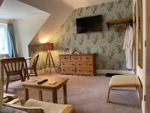 uma sala de estar com uma cómoda e uma televisão em Lancasters Cottage em Horsham