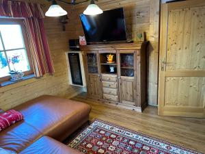 a living room with a couch and a flat screen tv at Gerstbreinhütte in Bad Sankt Leonhard im Lavanttal
