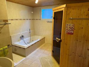 a bathroom with a tub and a sink and a bath tub at Gerstbreinhütte in Bad Sankt Leonhard im Lavanttal +18 photos