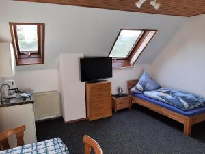 a small room with a bed and a tv at Gästezimmer Löhrbacher Tal in Birkenau