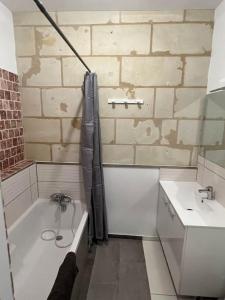 ein Badezimmer mit einer Badewanne und einem Waschbecken in der Unterkunft Guest House de Céline et Benoît in Rivarennes