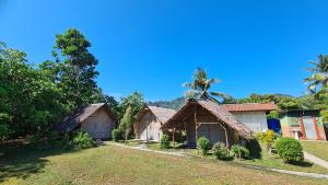 a group of bungalows with palm trees in the background at koh mook oyoy reggaebar bungalow in Ko Mook