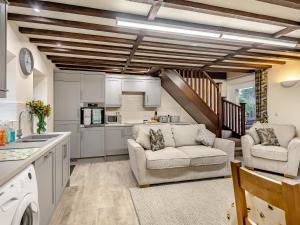a living room with two chairs and a kitchen at Two Chainbridge Barns in Wainfleet All Saints