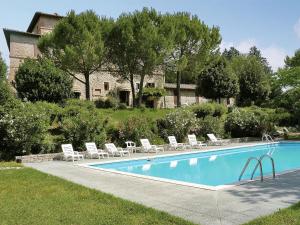 a swimming pool with lounge chairs and a house at Charming apartment in Mantignana with shared pool in Mantignana