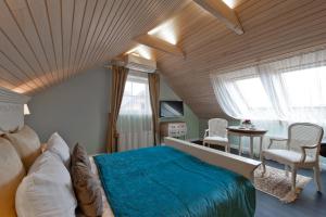 una camera con un grande letto e un tavolo con sedie di Viva Trakai a Trakai