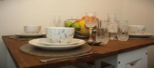 una mesa de madera con platos y vasos. en The Annexe, en Thorpe